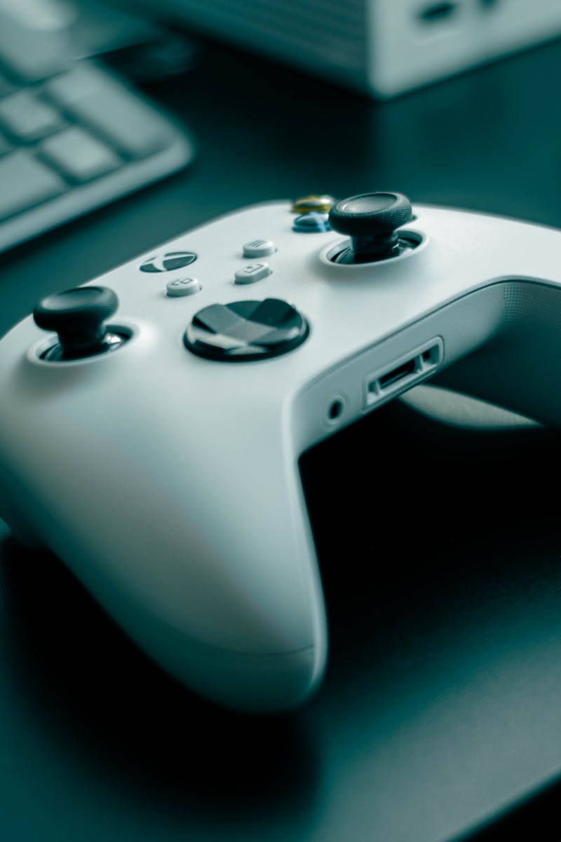 Close-up of a white game controller on a sleek desk, highlighting technology and gaming.